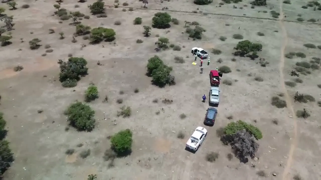 Brigada de topografía y vehículos en terreno rocoso, desde dron