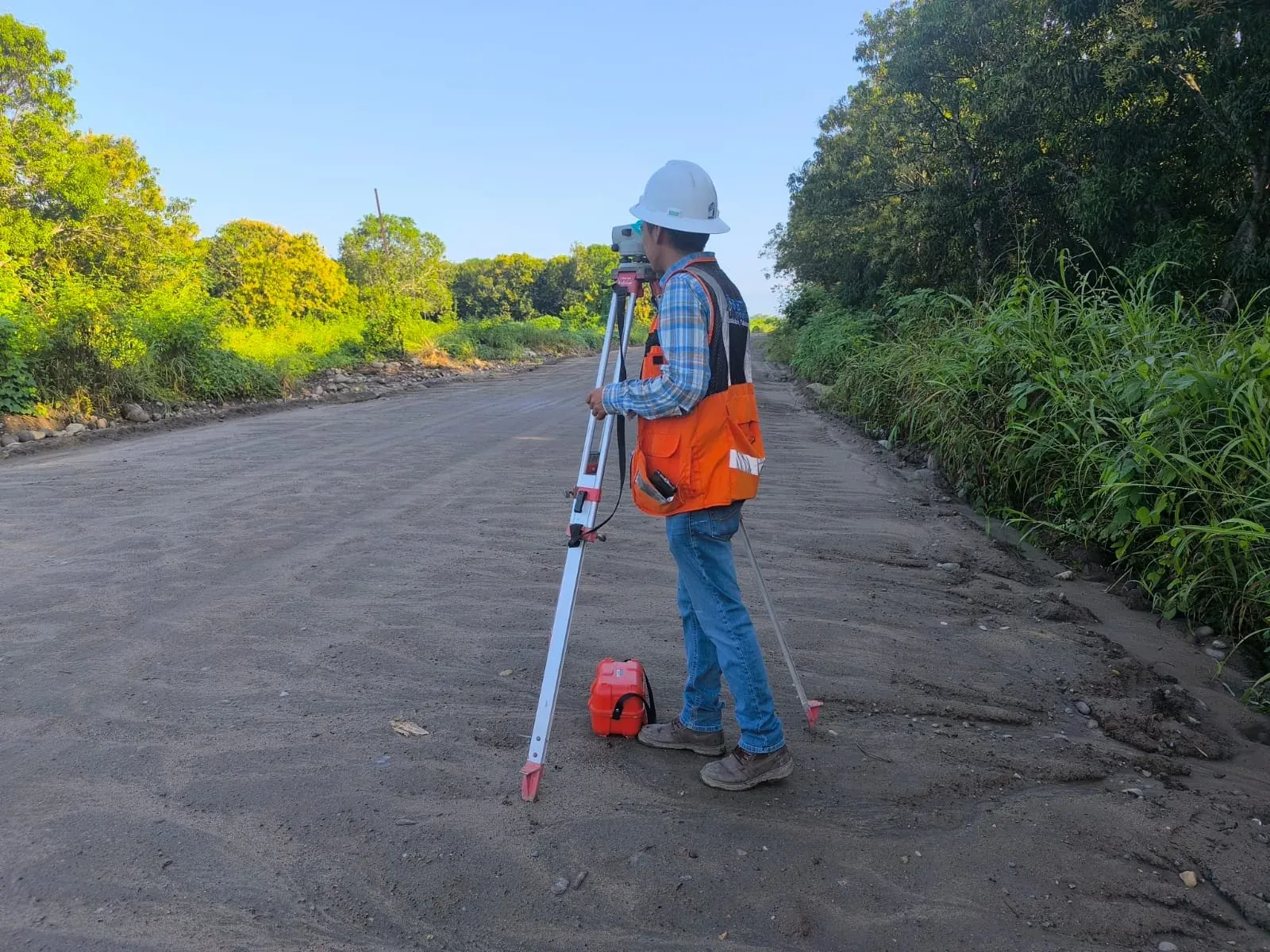 Topógrafo con estación total en camino