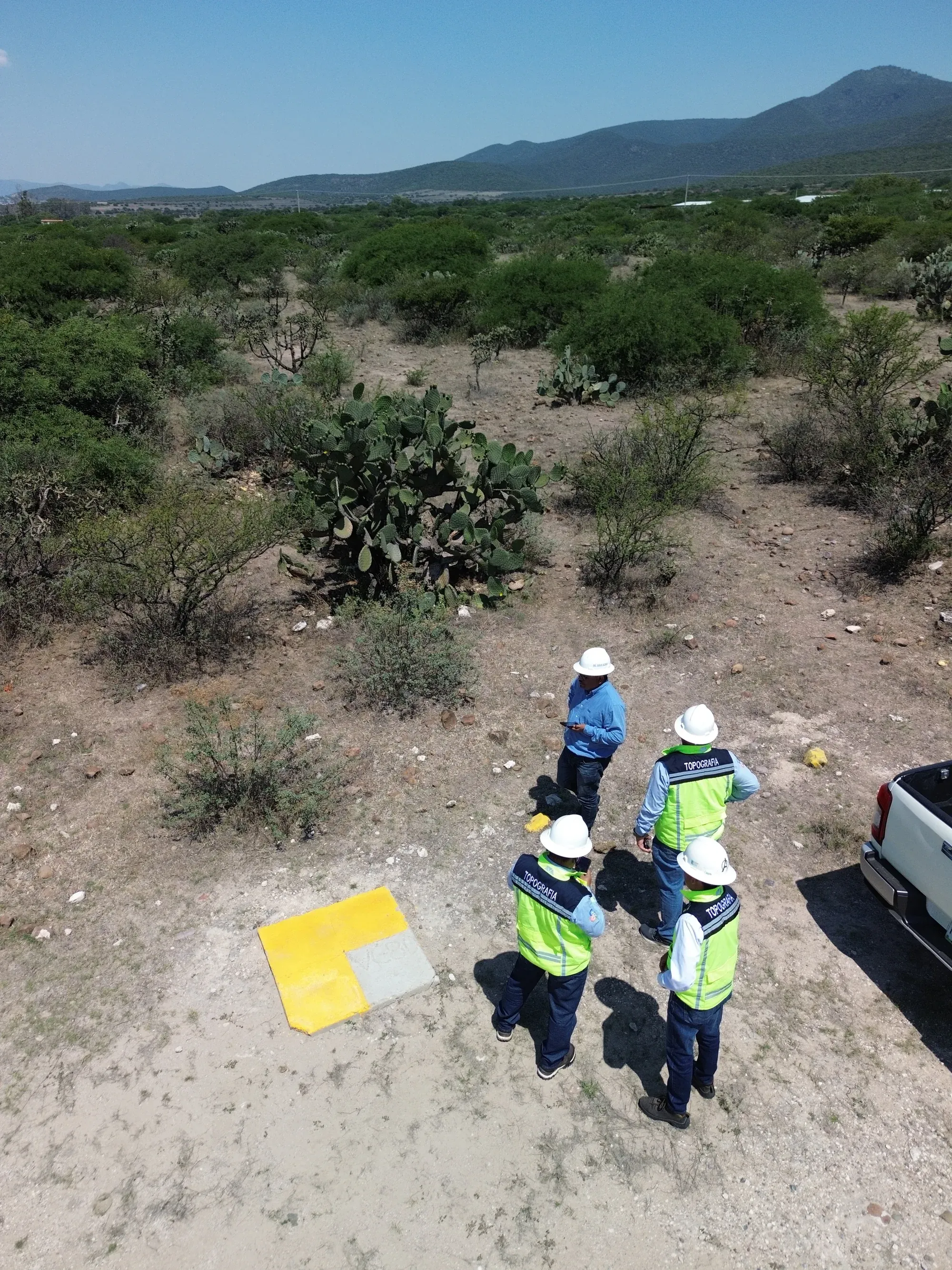 Cuadrilla junto a placa de control en el monte, vista cenital