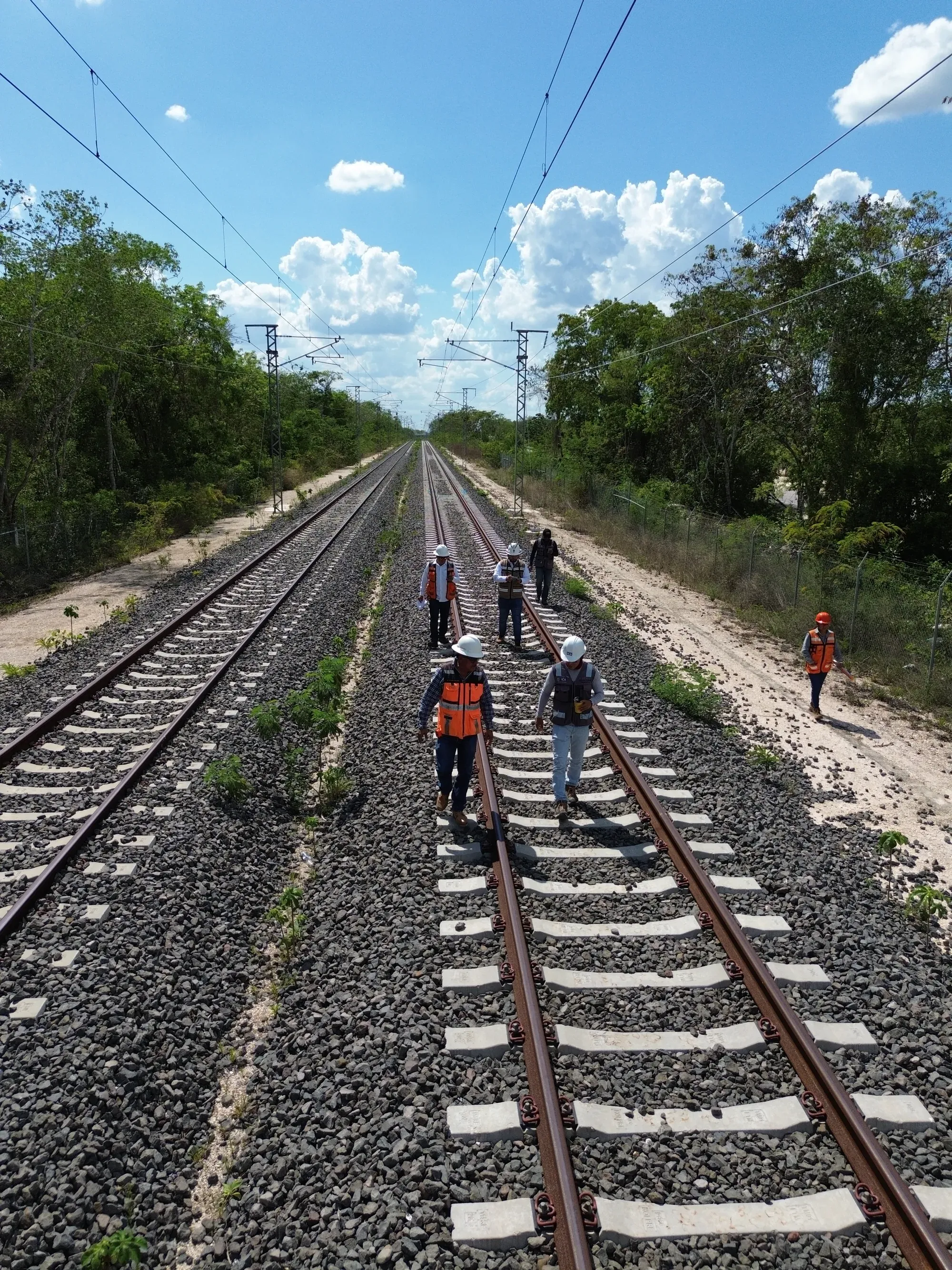 Brigada caminando sobre la vía bajo catenaria, desde dron