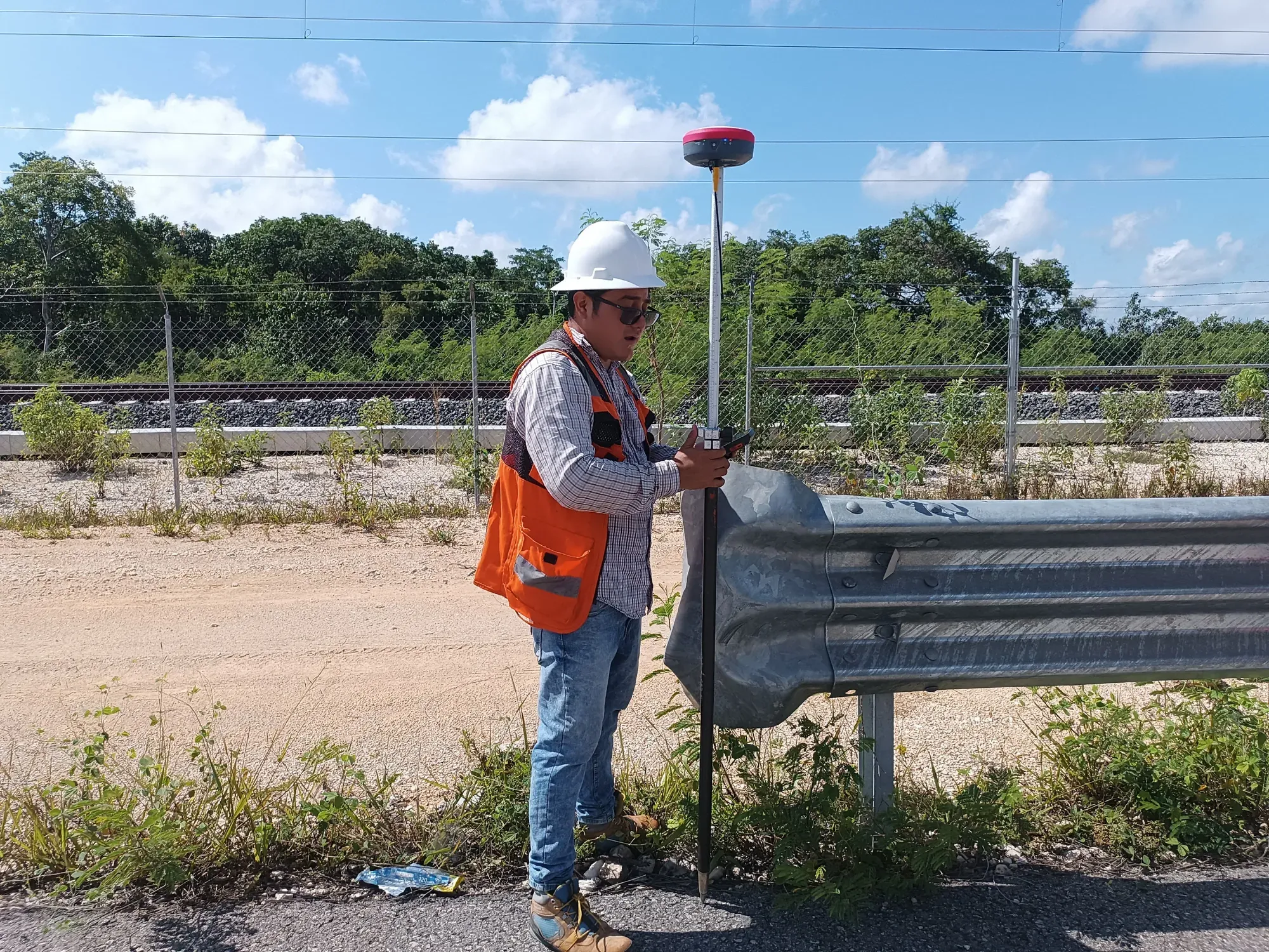 Receptor GNSS RTK sobre bastón junto a la vía