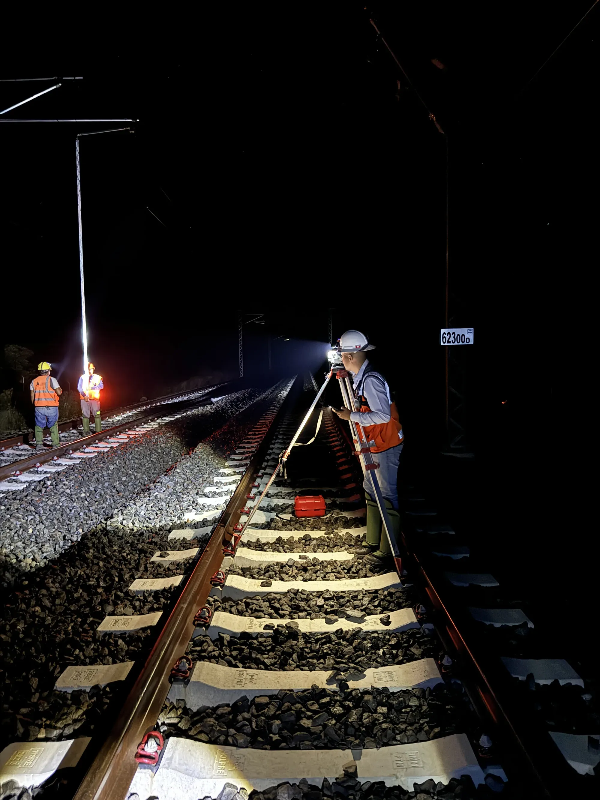 Brigada nocturna sobre la vía con lámparas de trabajo
