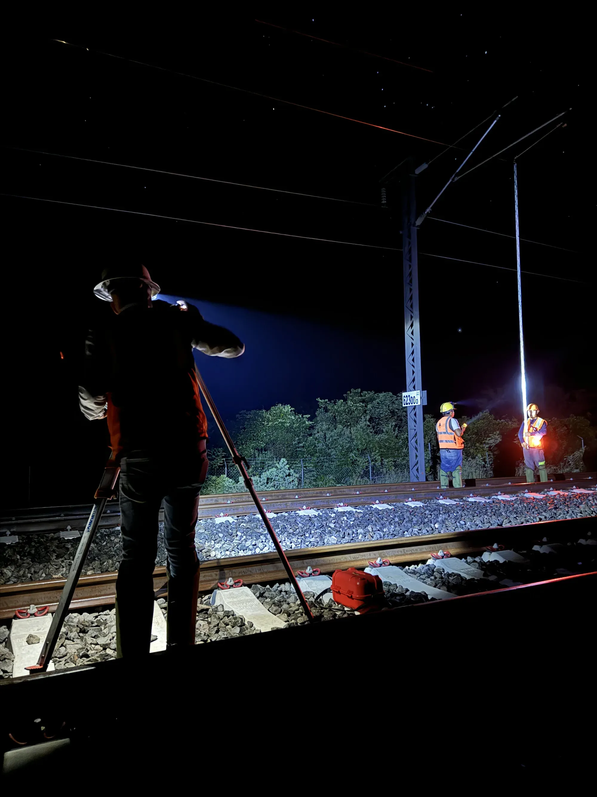Silueta de topógrafo con estación total durante ventana nocturna