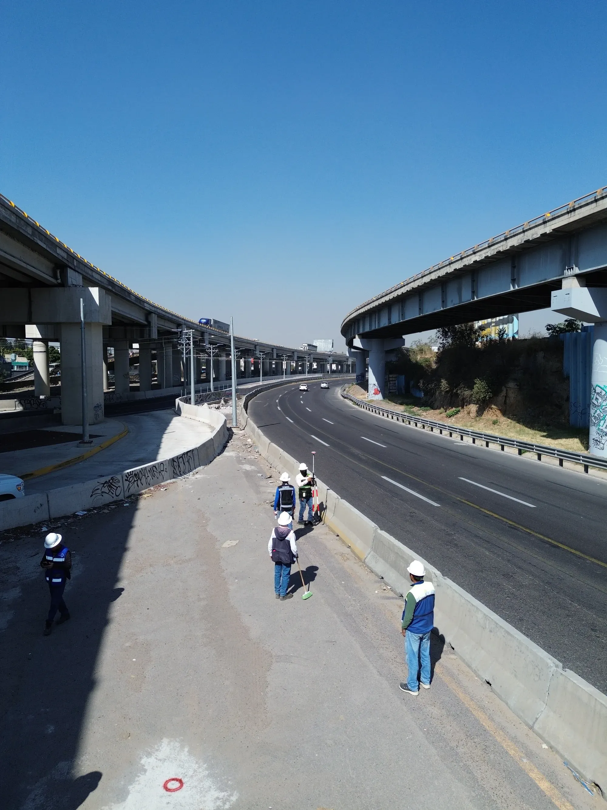 Brigada trabajando bajo el viaducto elevado, desde dron