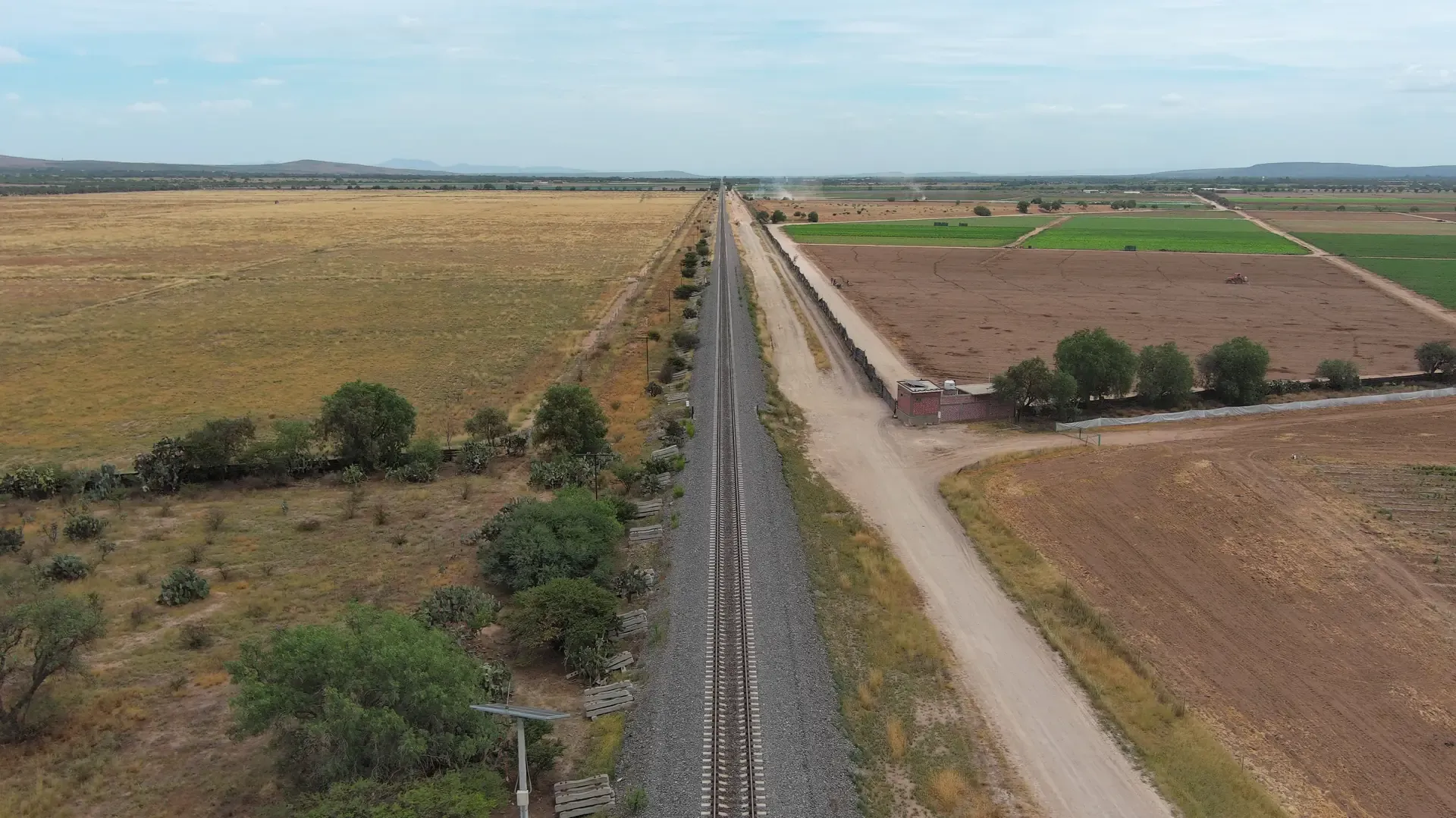 Vía férrea con canal y campos de cultivo, fotografía aérea